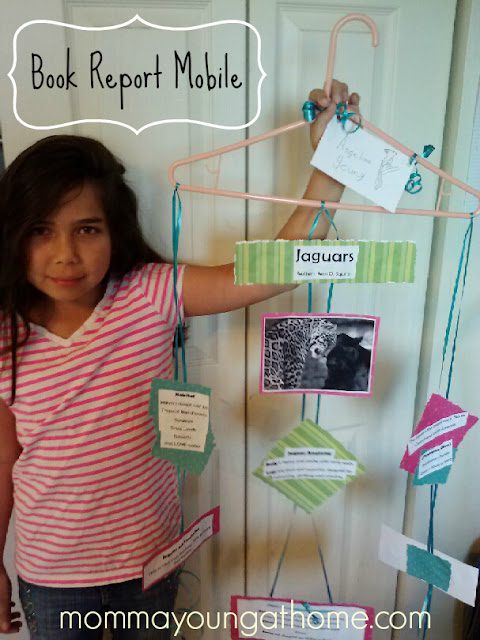A girl stays next to a book report cell manufactured off an steel hanger and index cards as an exemplary of creative book report ideas