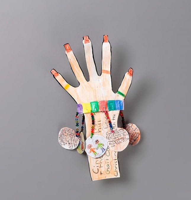 ONE decorated paper hand with paper amulets hook off of it